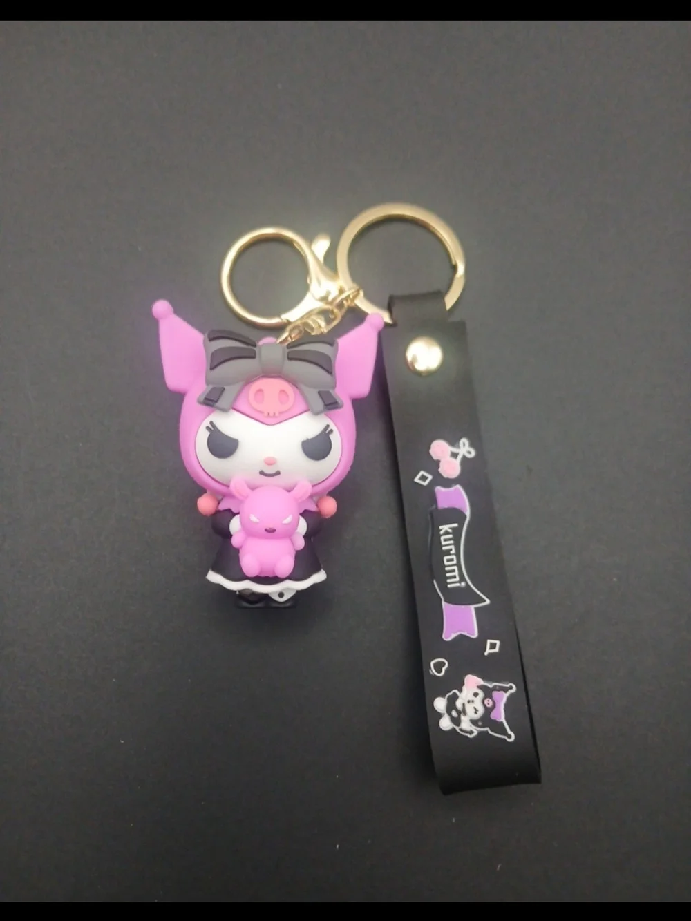 Sanrio Kuromi keychain features Kuromi holding a small pink teddy bear